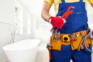 plumber with tool belt standing in bathroo